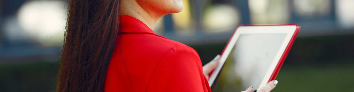Frau in roter Bluse hält rotes Tablet in der Hand